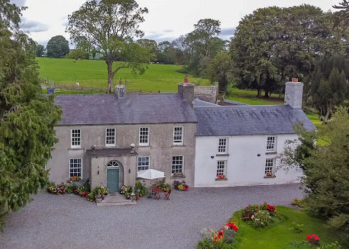Large two story country house with gravel driveway