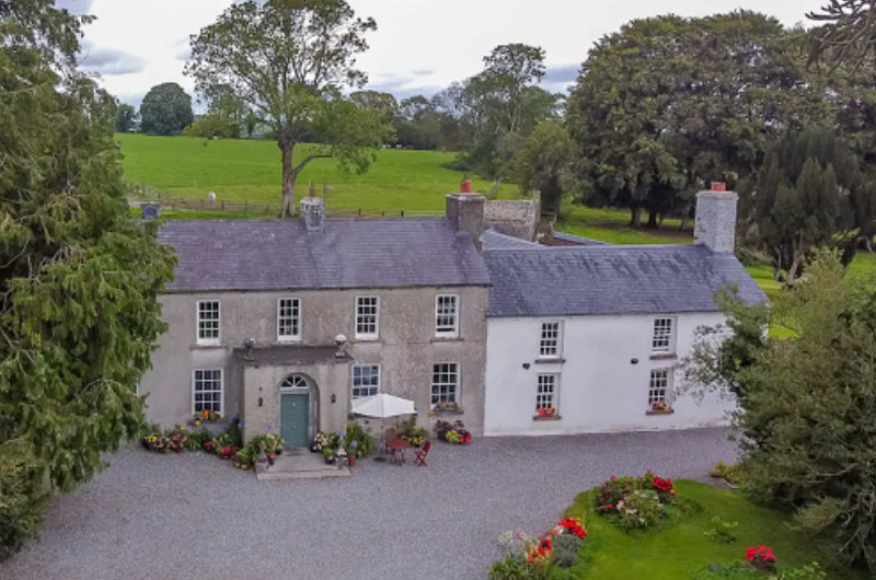Large two story country house with gravel driveway