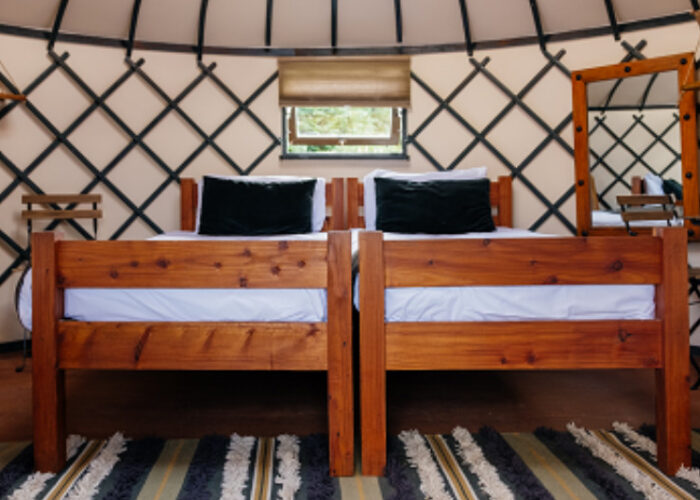 Two Twin Wooden Beds Inside A Yurt Interior