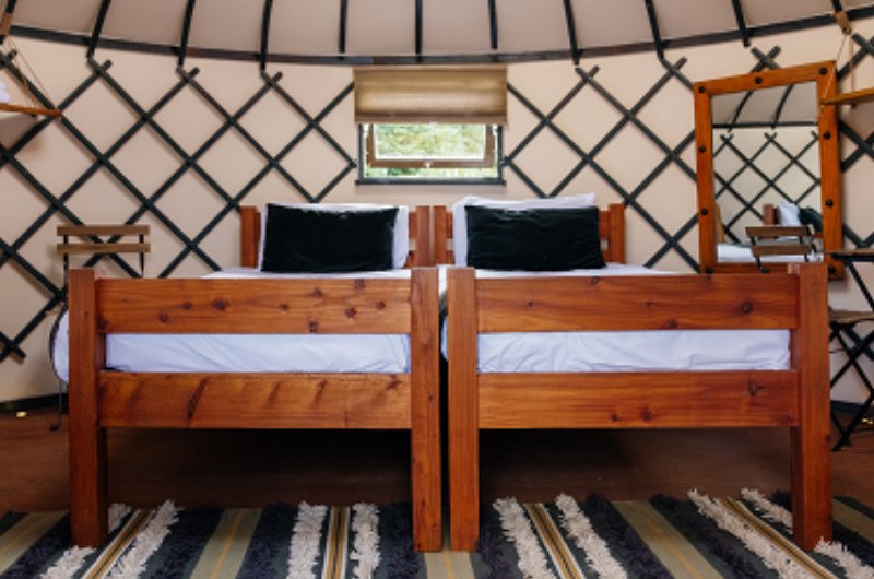 Two Twin Wooden Beds Inside A Yurt Interior