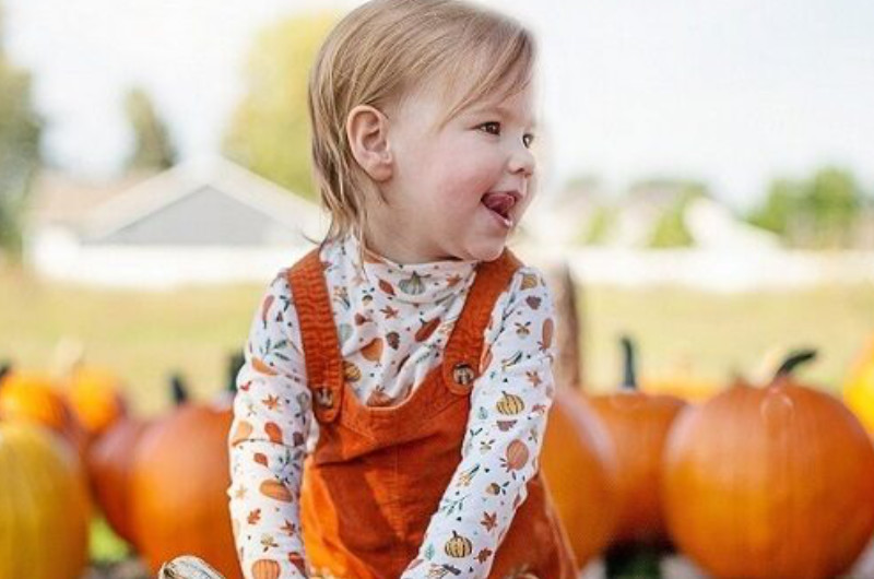Smiling Young Girl In Pumpkin Patch