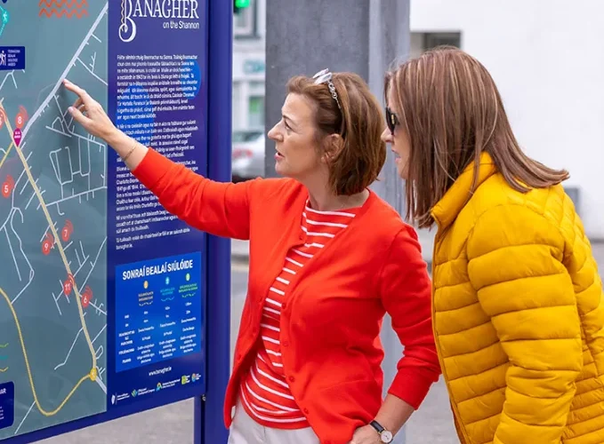 two women looking at map sign