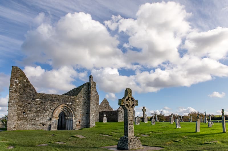 Ancient Stone Ruins And Celtic Crosses Under Clouds