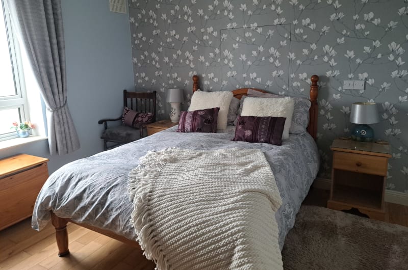 Bedroom with wooden bed and floral wallpaper
