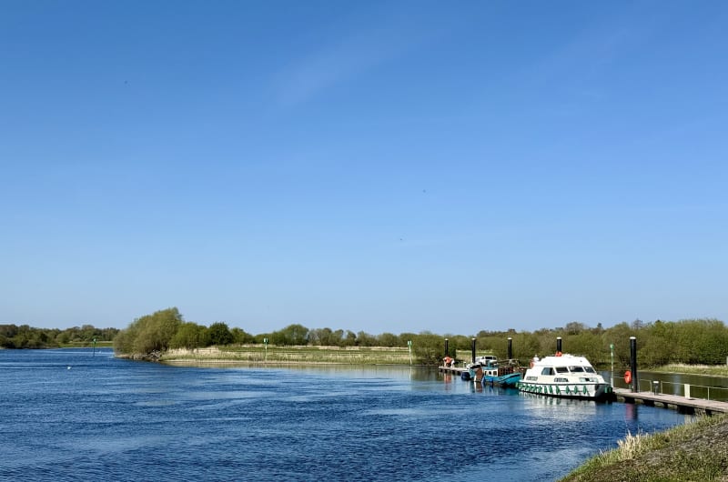 Boats Docked At A River Pier Blue Sky