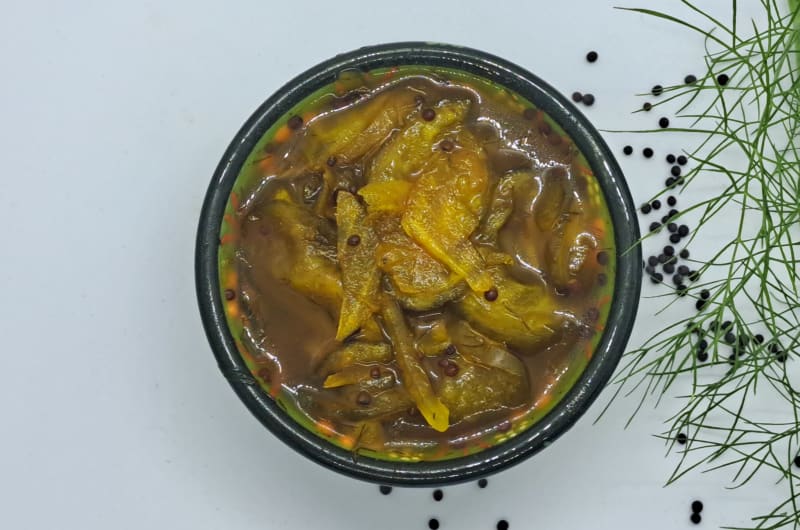 Bowl Of Mango Pickle With Fresh Dill Garnish