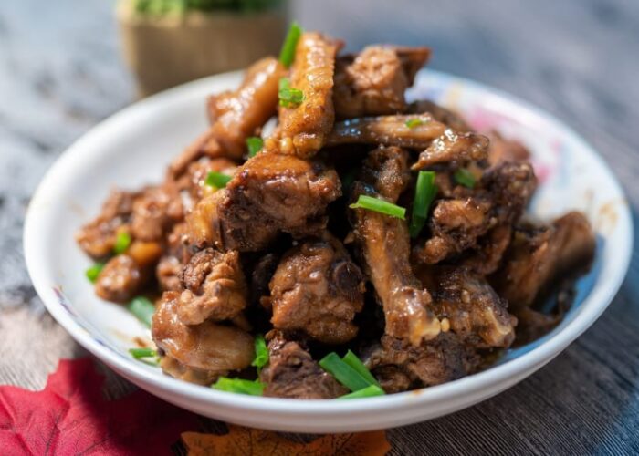 Braised Chicken With Green Onions On White Plate