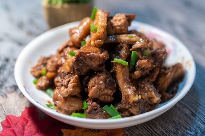 Braised Chicken With Green Onions On White Plate