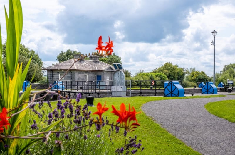 Canal lock house with blue gates and flowers