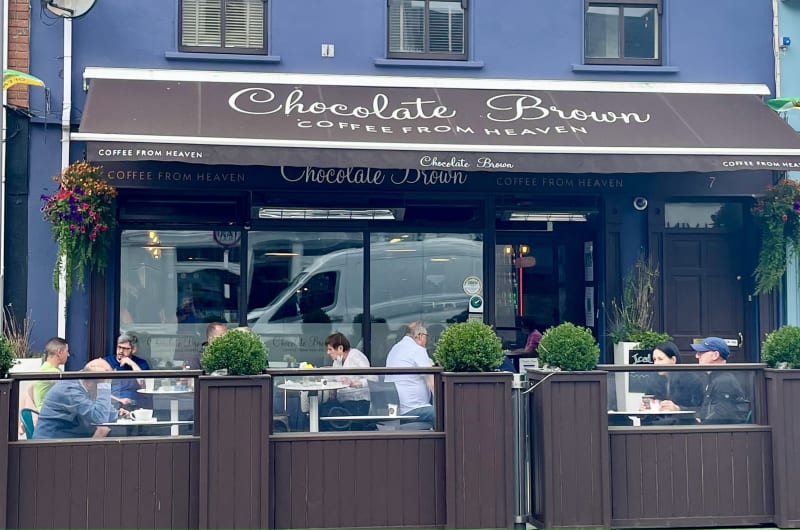 Chocolate Brown Coffee Shop Exterior With Patio Seating
