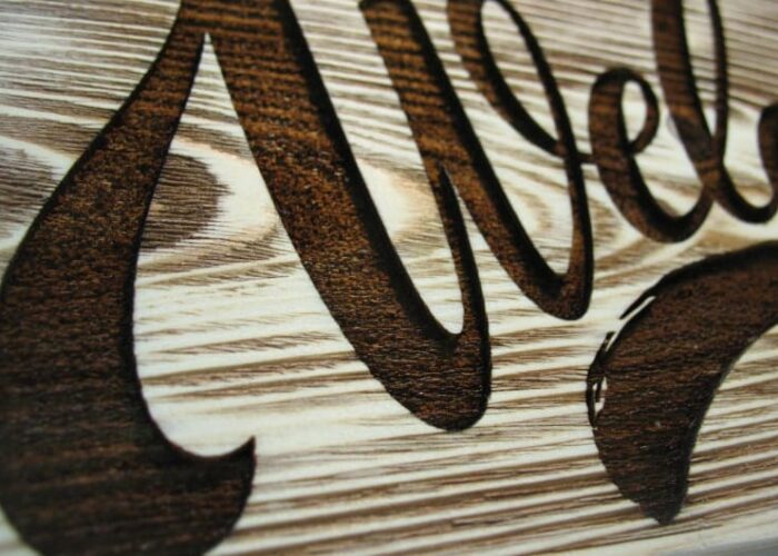 Close up of engraved wooden welcome sign