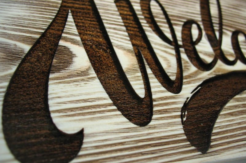 Close up of engraved wooden welcome sign