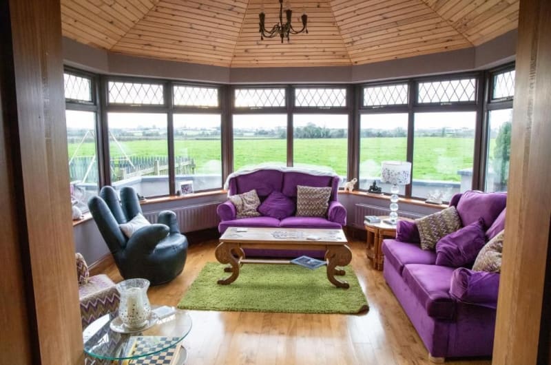 Conservatory Interior With Purple Sofas And Garden View