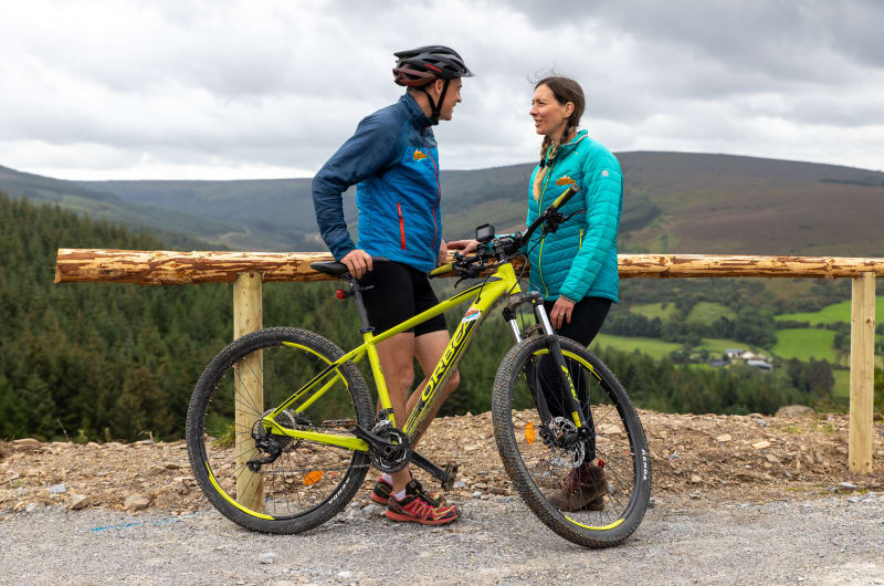 Couple with Orbea mountain bike at scenic overlook drsltv