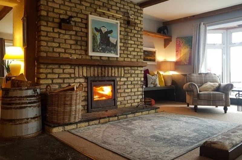 Cozy Living Room With Brick Fireplace And Stove