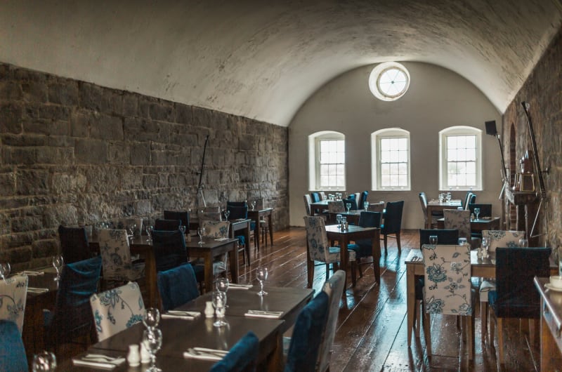 Dining room with vaulted ceiling and stone wall
