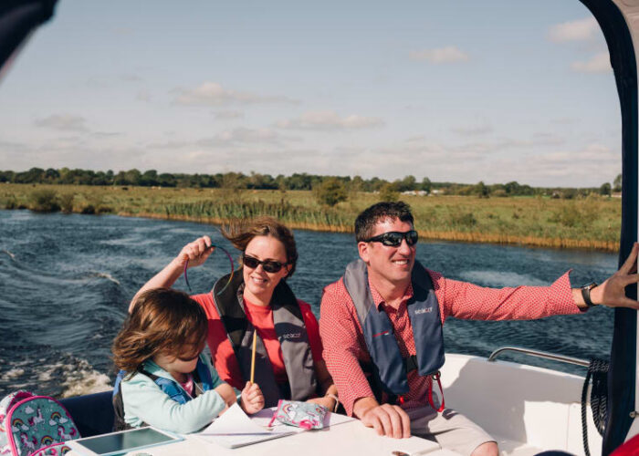 Family Wearing Life Jackets On A Boat