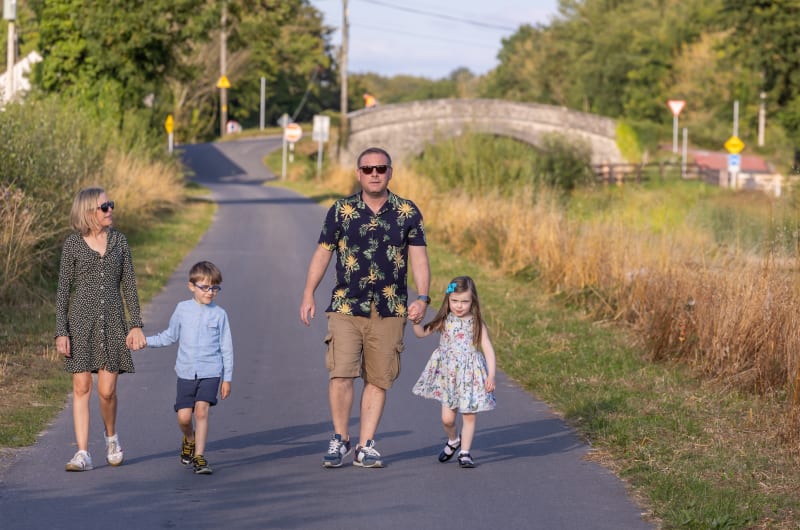 Family of four walking on a rural road