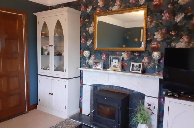 Family room with fireplace floral wallpaper and hutch