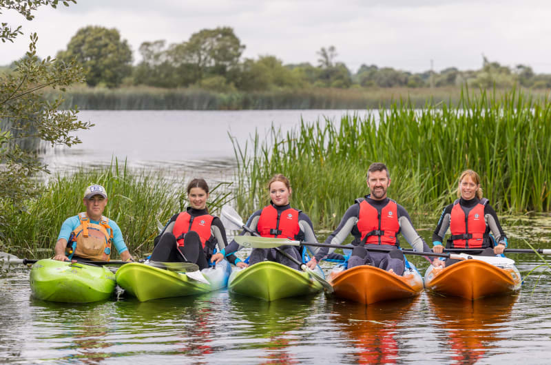 Five People In Kayaks On A Lake