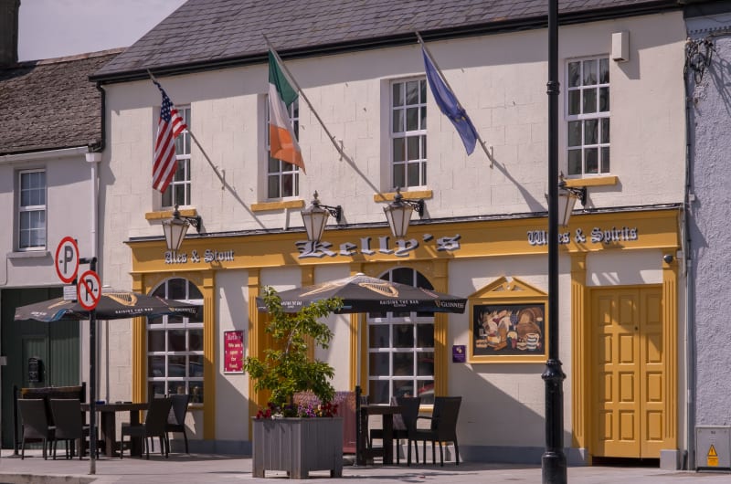Kellys Pub Exterior Yellow Trim Outdoor Seating