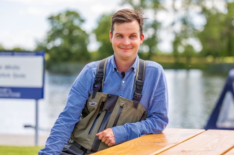 Man wearing fishing waders near a lake