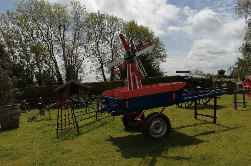 Miniature Red Windmill Mounted On Colorful Farm Cart lxd79y