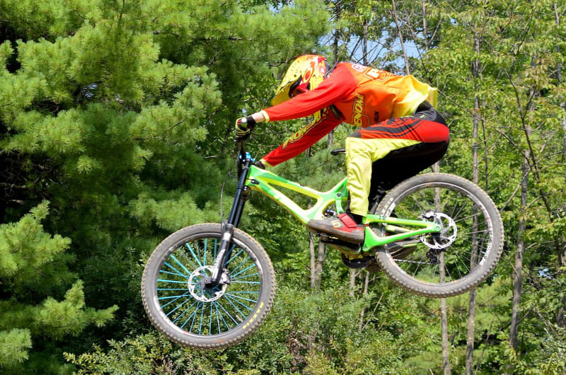 Mountain Biker Jumping on Lime Green Bike