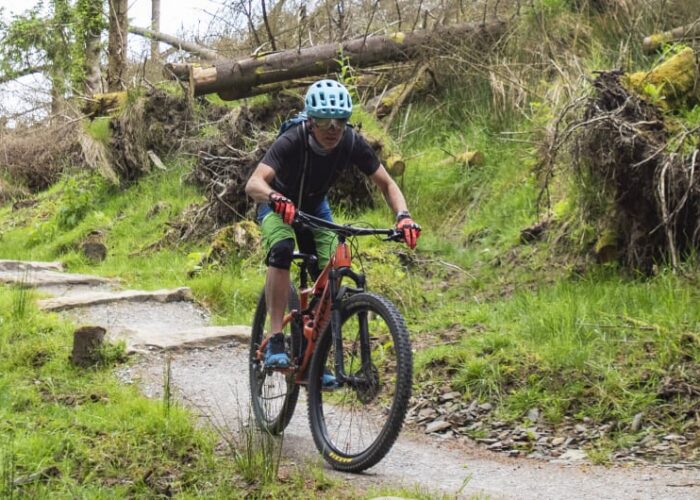 Mountain Biker Riding On A Rocky Forest Trail