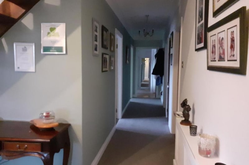 Narrow residential hallway with framed wall art