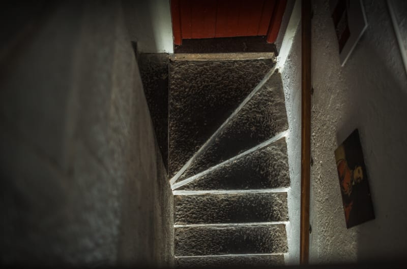 Narrow stone staircase winding between white walls