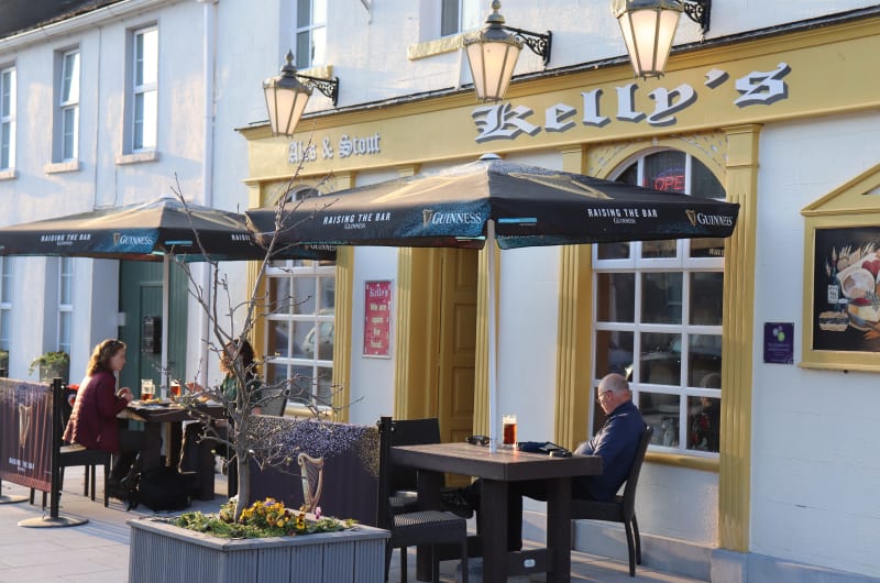 Outdoor seating at Kellys pub with Guinness umbrellas
