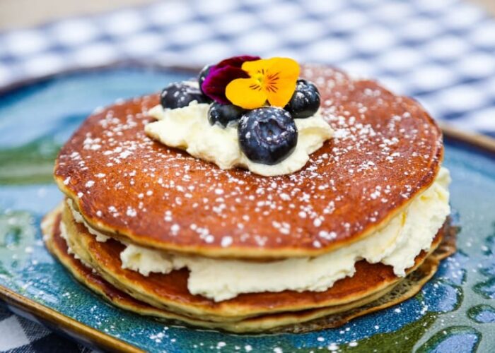 Pancake Stack With Cream Blueberries And Edible Flowers