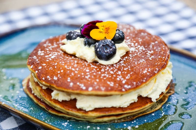 Pancake Stack With Cream Blueberries And Edible Flowers