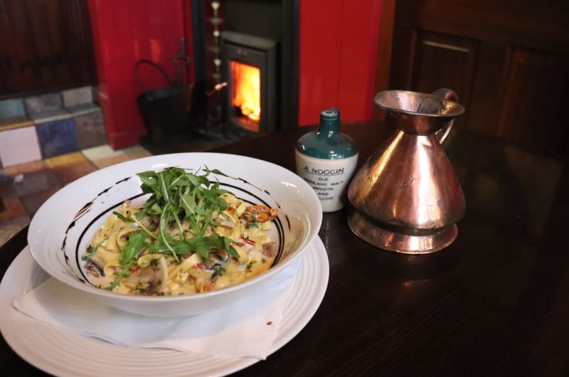 Pasta dish with arugula near a warm fireplace