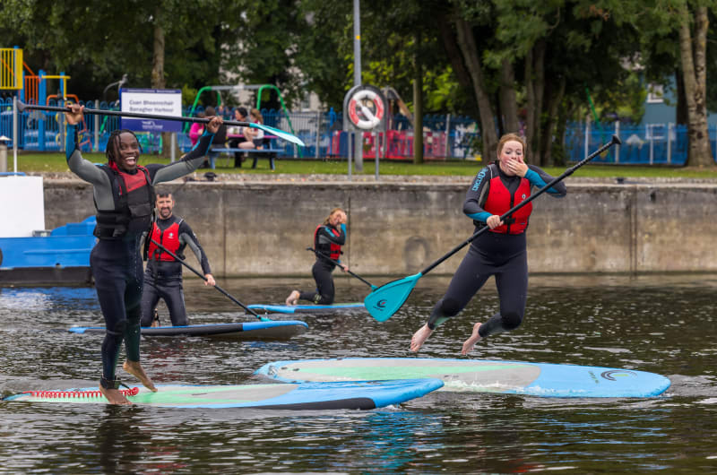 People Jumping From Paddleboards At Banagher Harbour
