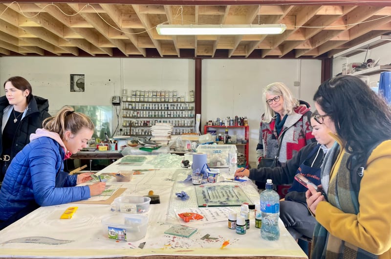 People Painting Glass Panels In Art Studio