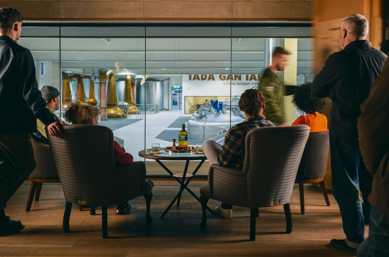 People Viewing Whiskey Distillery From Modern Lounge Area