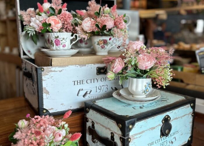 Pink roses in teacups on vintage decorative chests
