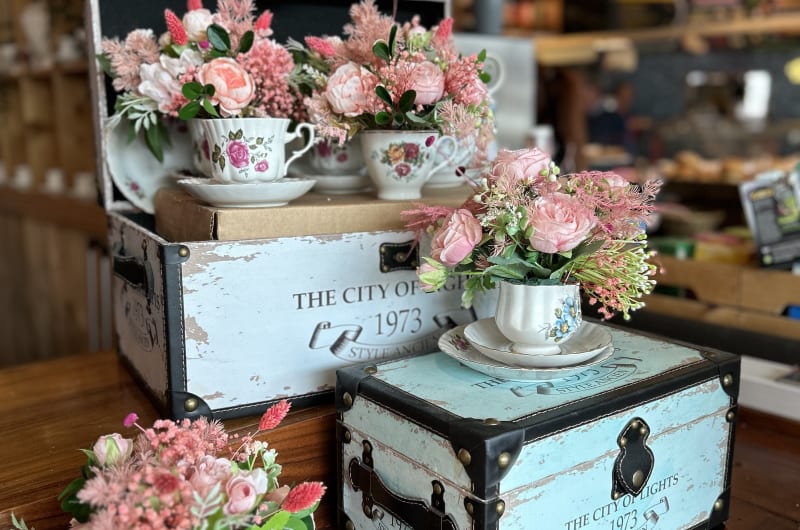 Pink roses in teacups on vintage decorative chests