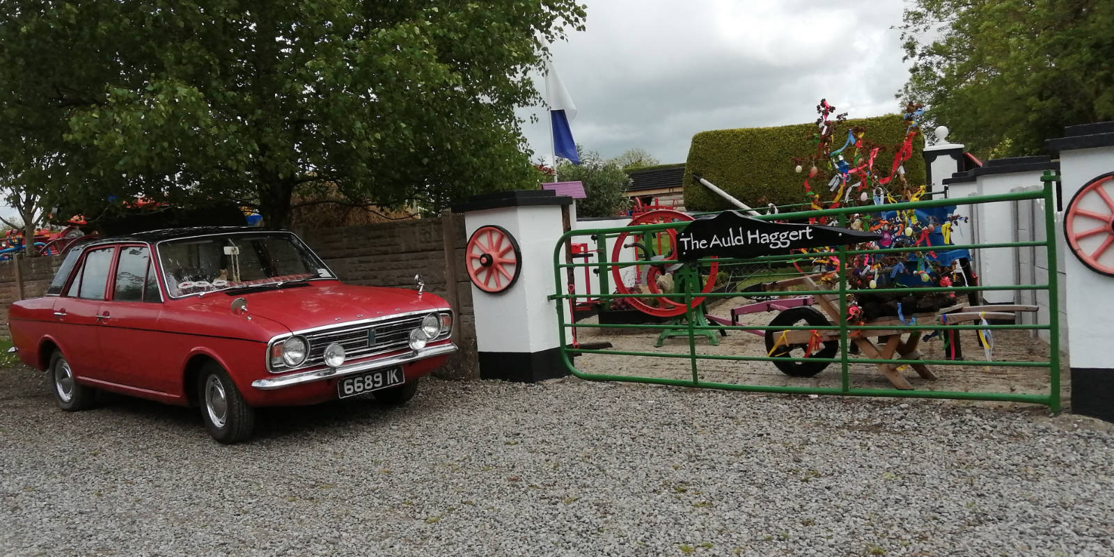 Red vintage car by The Auld Haggart sign