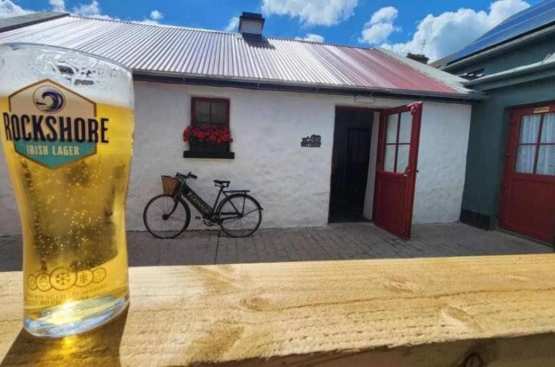 Rockshore Irish Lager glass outside white cottage