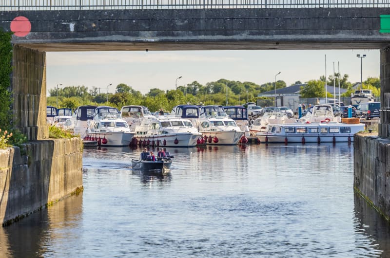 Small Boat Entering Marina Under Bridge