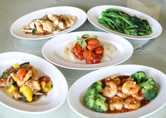Stir fried Chinese dishes on white plates