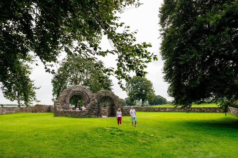 Stone Ruins Of Clonmacnoise With Visitors Walking
