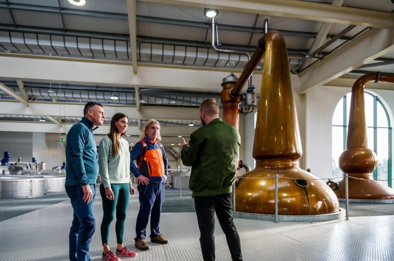 Tour group viewing copper stills in distillery interior