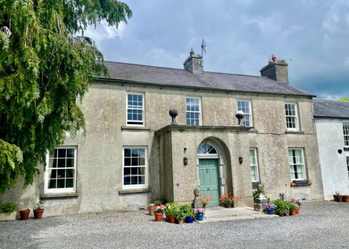 Traditional Stone House With Green Door And Flowers