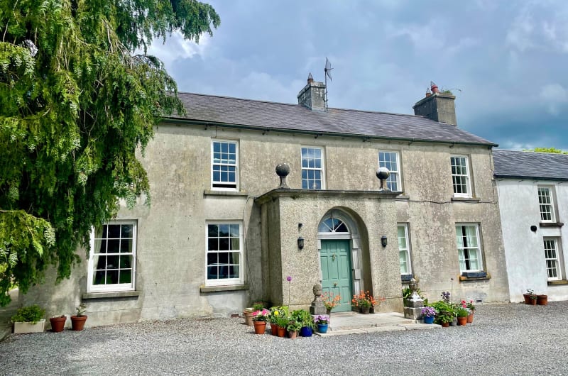 Traditional Stone House With Green Door And Flowers