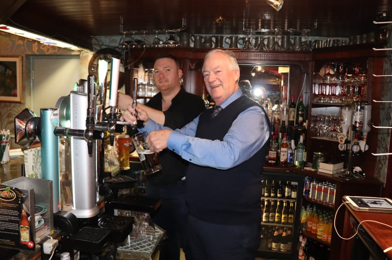 Two Men Pouring Pints At A Pub Bar