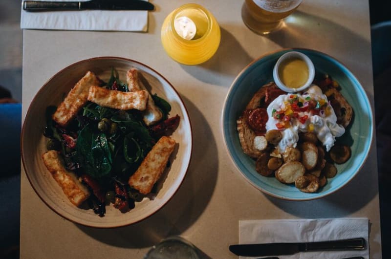 Two plates of food and drinks on table